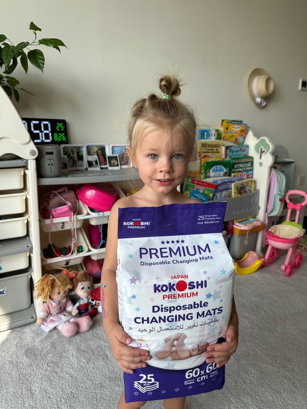 Kokoshi Family+ child holding Kokoshi Premium Changing Mats